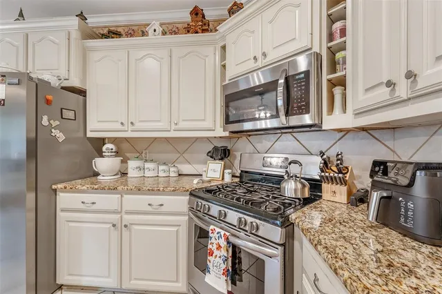 a kitchen with stainless steel appliances granite countertop a stove and a sink