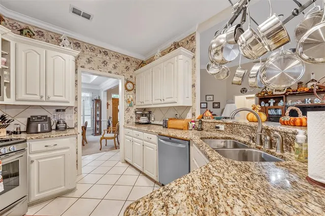 a kitchen with stainless steel appliances granite countertop a sink stove and cabinets