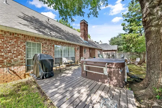a view of a patio with table and chairs barbeque potted plants and large tree