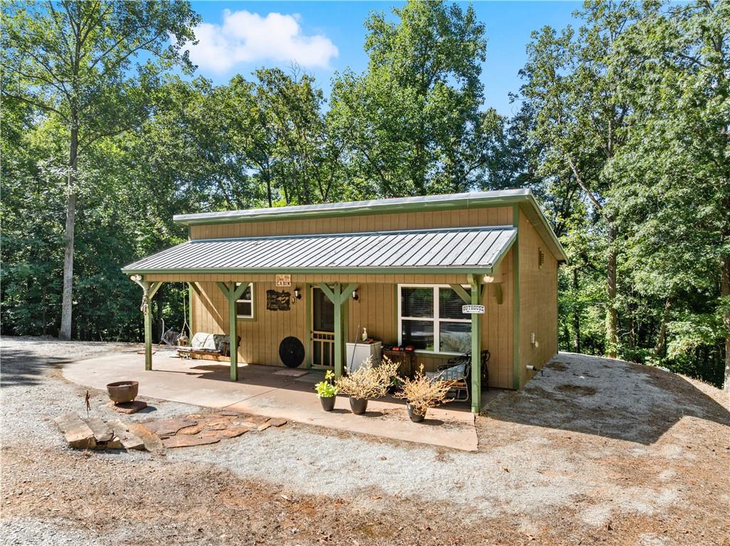 318 Jim Grizzle Road Royston, GA 30662 - Photo 5 of 56 a view of a patio with table and chairs under an umbrella with large trees