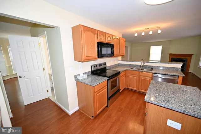a kitchen with granite countertop a sink and a stove top oven