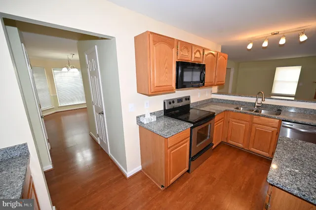 a bathroom with a granite countertop sink toilet mirror vanity and bathtub