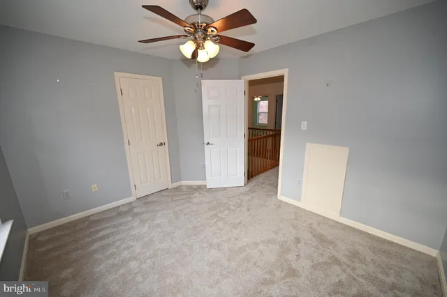 a view of an empty room with wooden floor and windows