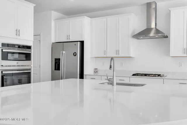 a kitchen with granite countertop a stove a sink and a refrigerator