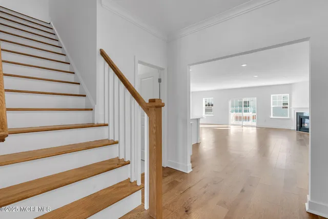 a view of a living room with wooden floor and windows