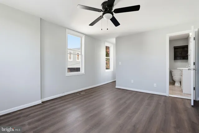 a view of empty room with wooden floor and window
