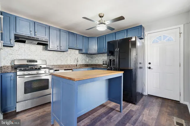 a kitchen with stainless steel appliances granite countertop a refrigerator stove and sink