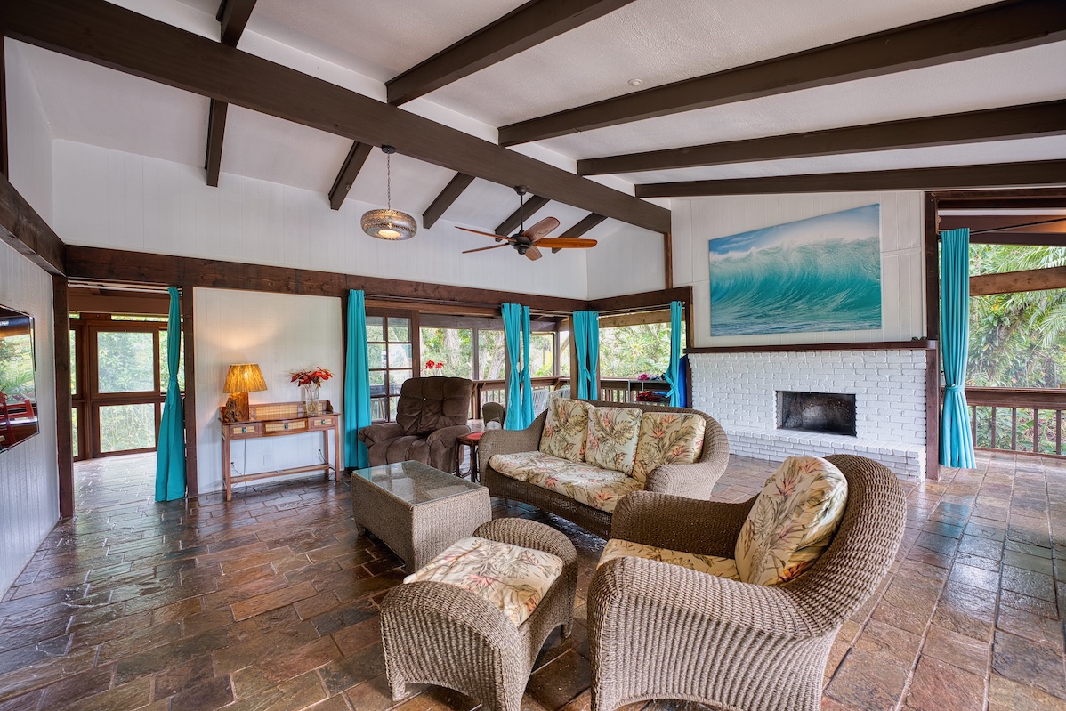 173 Opio Road Hilo, HI 96720 - Photo 15 of 27 a living room with furniture a fireplace and a floor to ceiling window