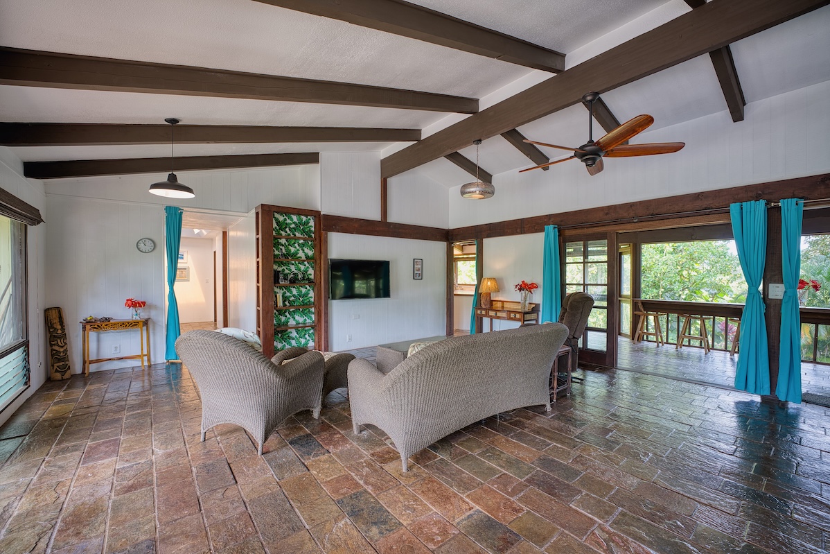 173 Opio Road Hilo, HI 96720 - Photo 16 of 27 a living room with furniture and a floor to ceiling window