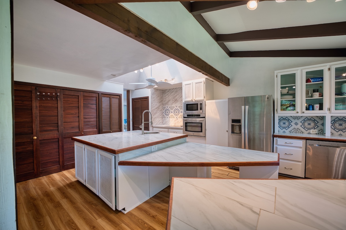 173 Opio Road Hilo, HI 96720 - Photo 19 of 27 a kitchen with stainless steel appliances kitchen island granite countertop a sink and wooden cabinets