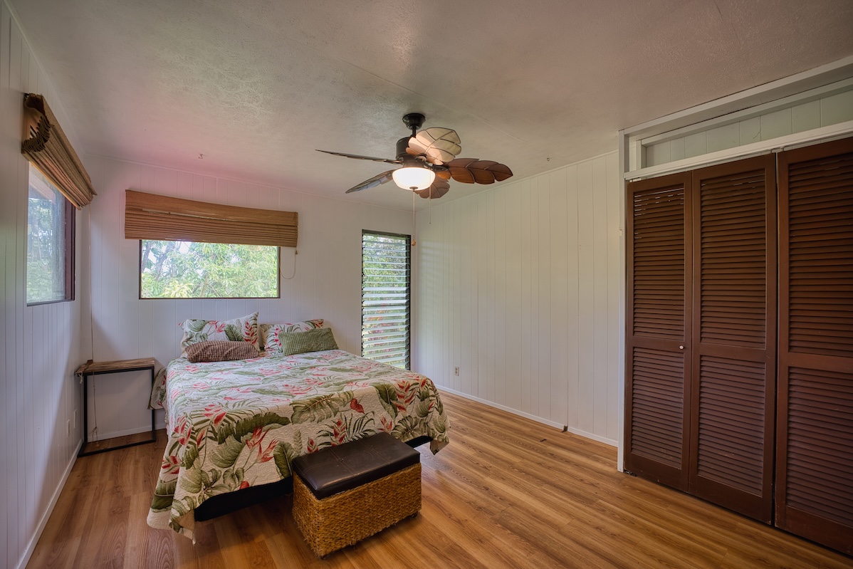 173 Opio Road Hilo, HI 96720 - Photo 20 of 27 a bedroom with a bed and wooden floor
