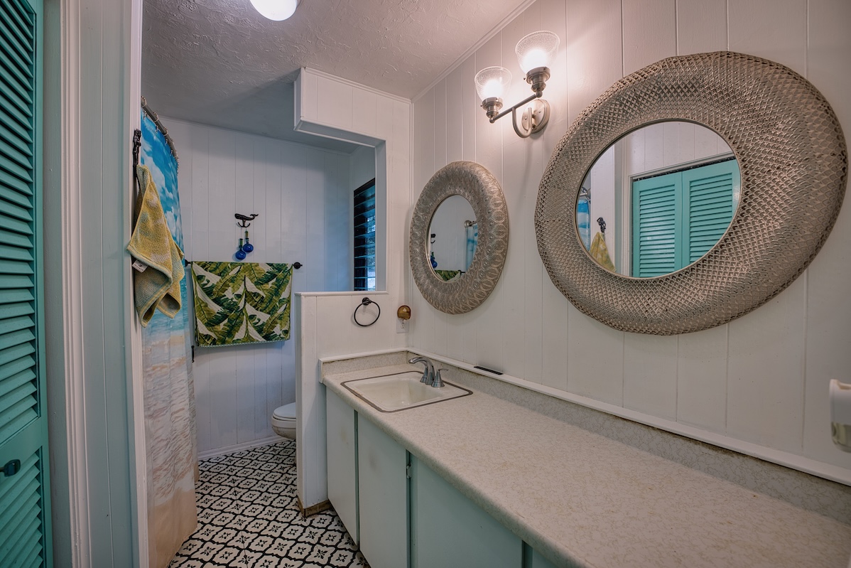 173 Opio Road Hilo, HI 96720 - Photo 21 of 27 a bathroom with a sink mirror and vanity
