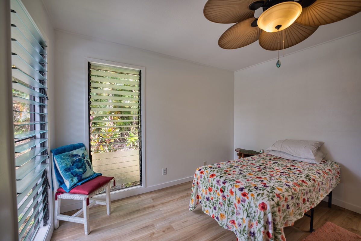 173 Opio Road Hilo, HI 96720 - Photo 22 of 27 a bedroom with a bed and chair