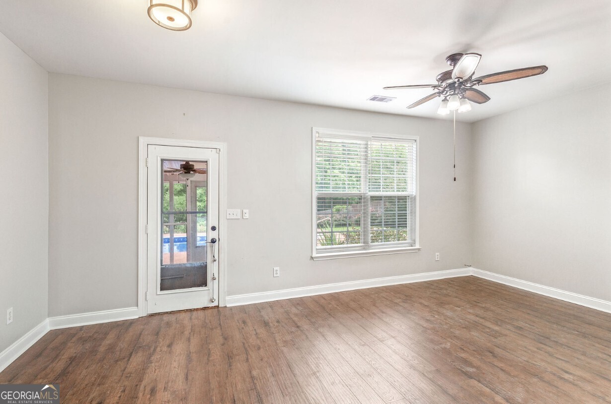 82 Newton Road LaGrange, GA 30240 - Photo 14 of 45 an empty room with wooden floor fan and windows