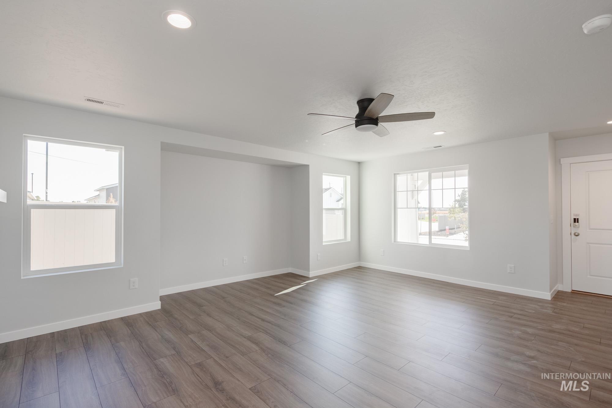 3270 West Morere Drive Meridian, ID 83642 - Photo 13 of 26 Empty room with dark wood-style floors, recessed lighting, and ceiling fan