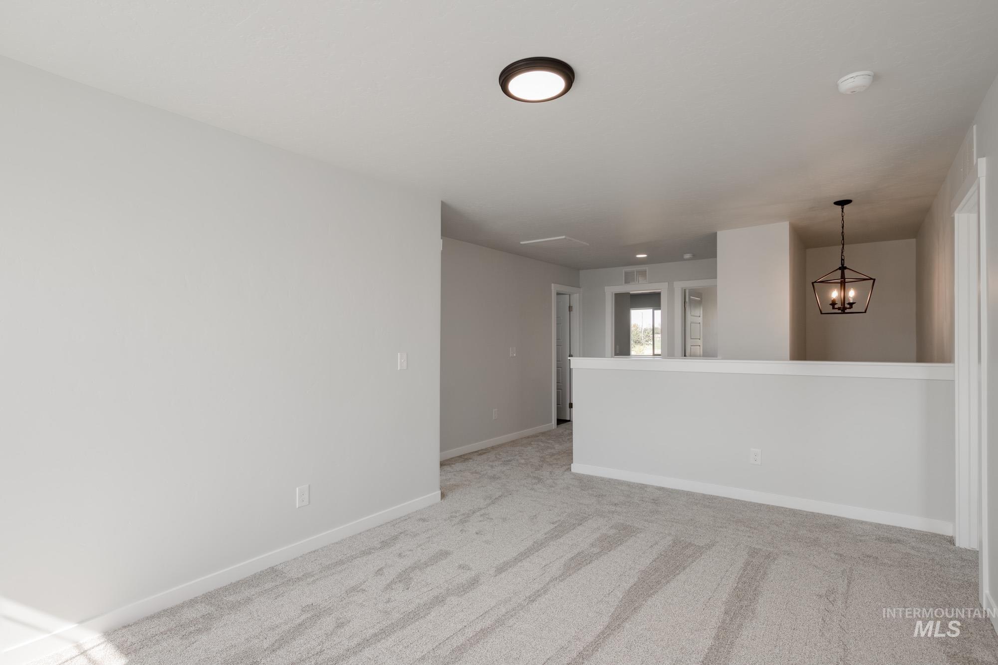 3270 West Morere Drive Meridian, ID 83642 - Photo 25 of 26 Empty room featuring light colored carpet and a chandelier