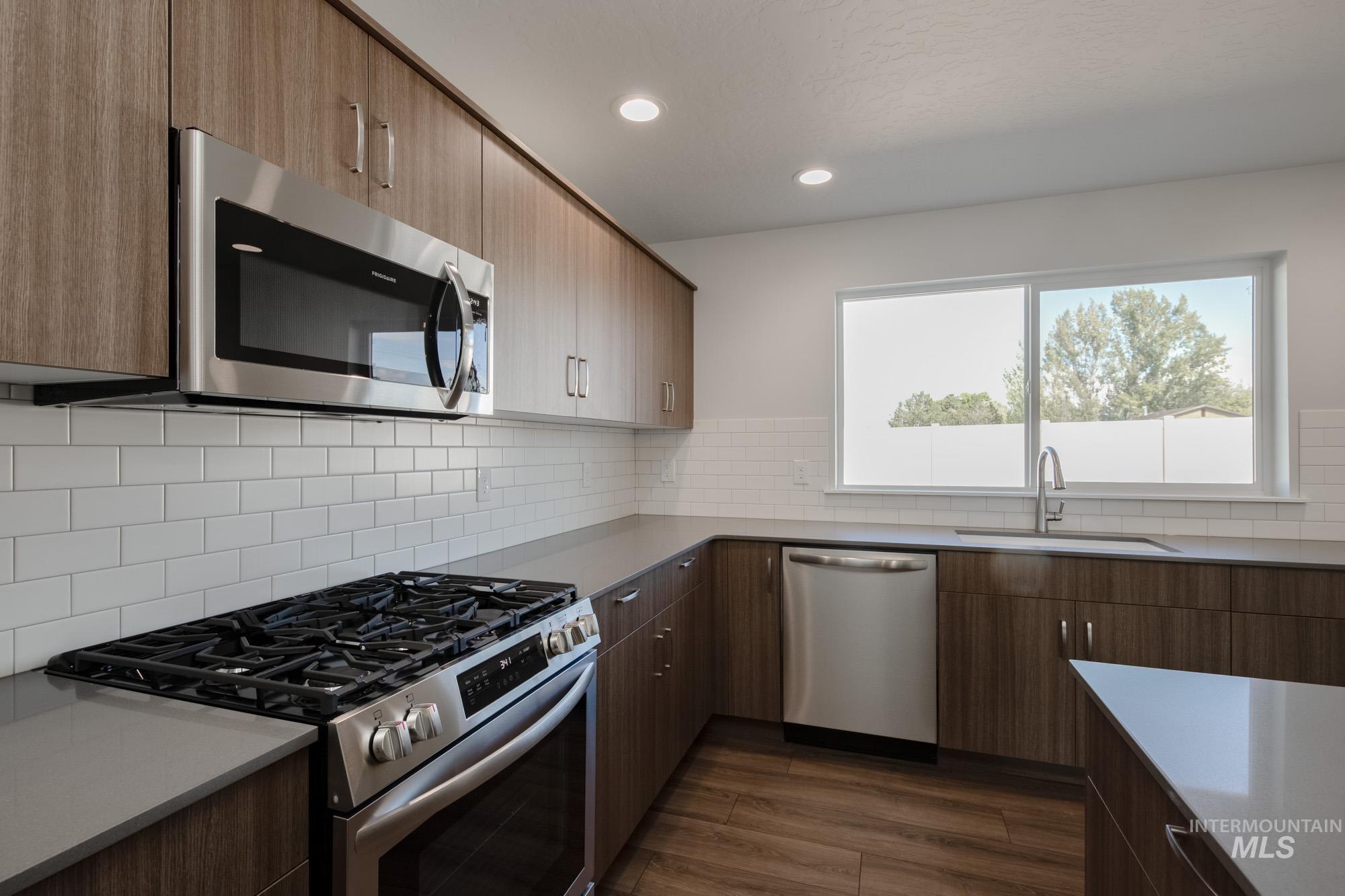 3270 West Morere Drive Meridian, ID 83642 - Photo 7 of 26 Kitchen featuring appliances with stainless steel finishes, recessed lighting, dark wood-style floors, modern cabinets, and decorative backsplash