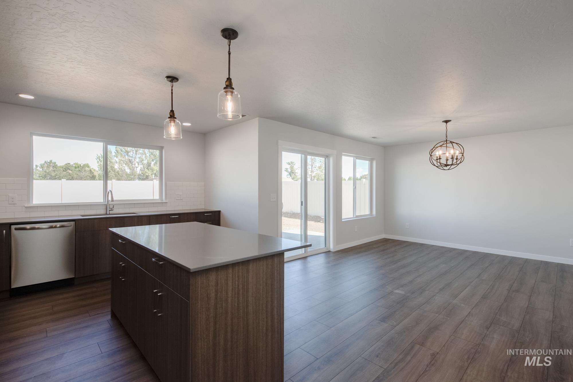 3270 West Morere Drive Meridian, ID 83642 - Photo 8 of 26 Kitchen with pendant lighting, dishwasher, dark wood-type flooring, a kitchen island, and backsplash