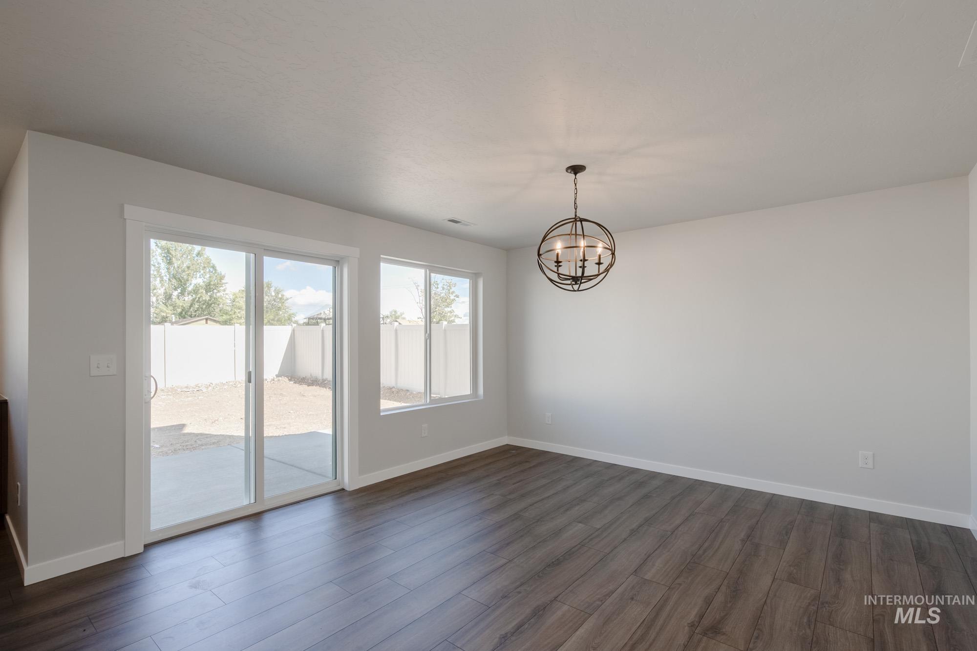 3270 West Morere Drive Meridian, ID 83642 - Photo 9 of 26 Unfurnished dining area with dark wood-style flooring and a chandelier