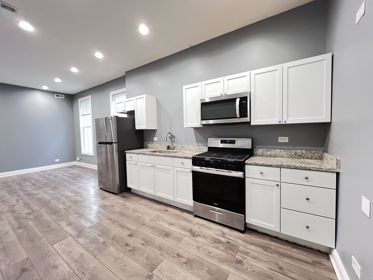 7057 South Normal Boulevard, Unit 2 Chicago, IL 60621 - Photo 12 of 46 a kitchen with granite countertop a stove a sink and a microwave