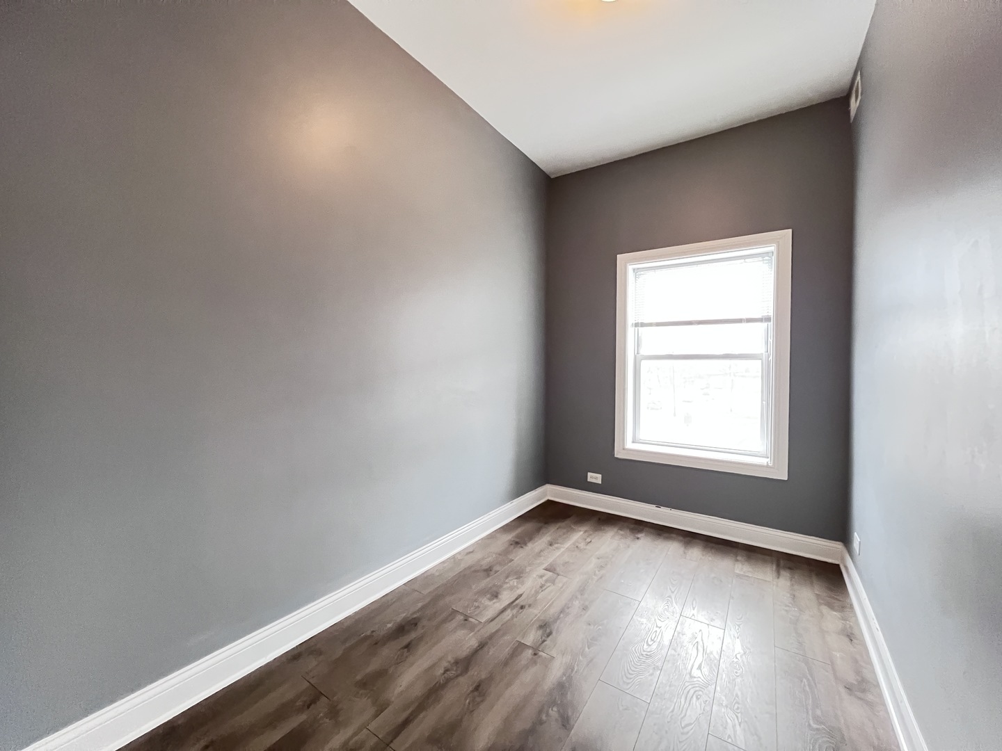 7057 South Normal Boulevard, Unit 2 Chicago, IL 60621 - Photo 15 of 46 an empty room with wooden floor and windows