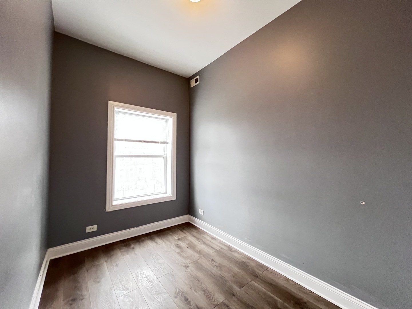 7057 South Normal Boulevard, Unit 2 Chicago, IL 60621 - Photo 17 of 46 an empty room with wooden floor and windows