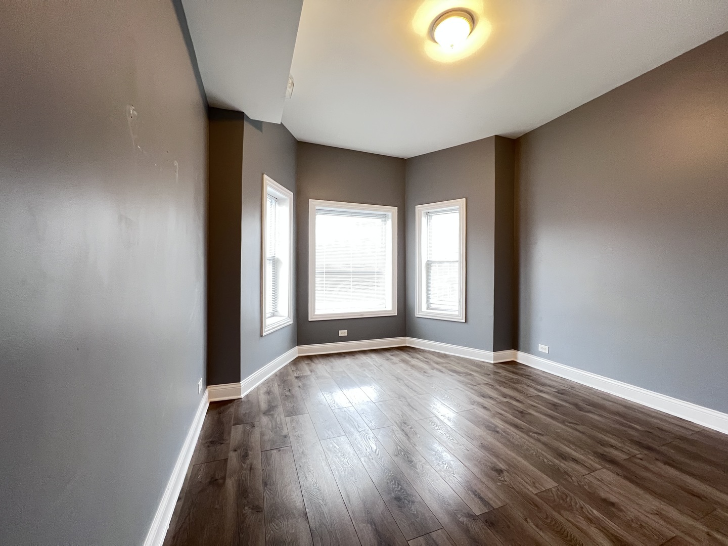 7057 South Normal Boulevard, Unit 2 Chicago, IL 60621 - Photo 21 of 46 a view of an empty room with wooden floor and a window