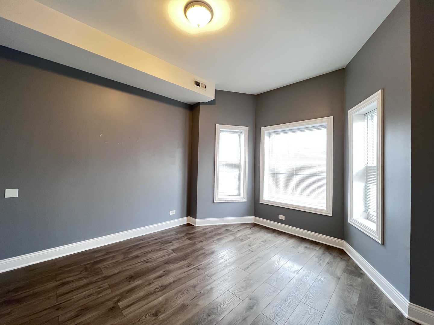 7057 South Normal Boulevard, Unit 2 Chicago, IL 60621 - Photo 24 of 46 an empty room with wooden floor and windows