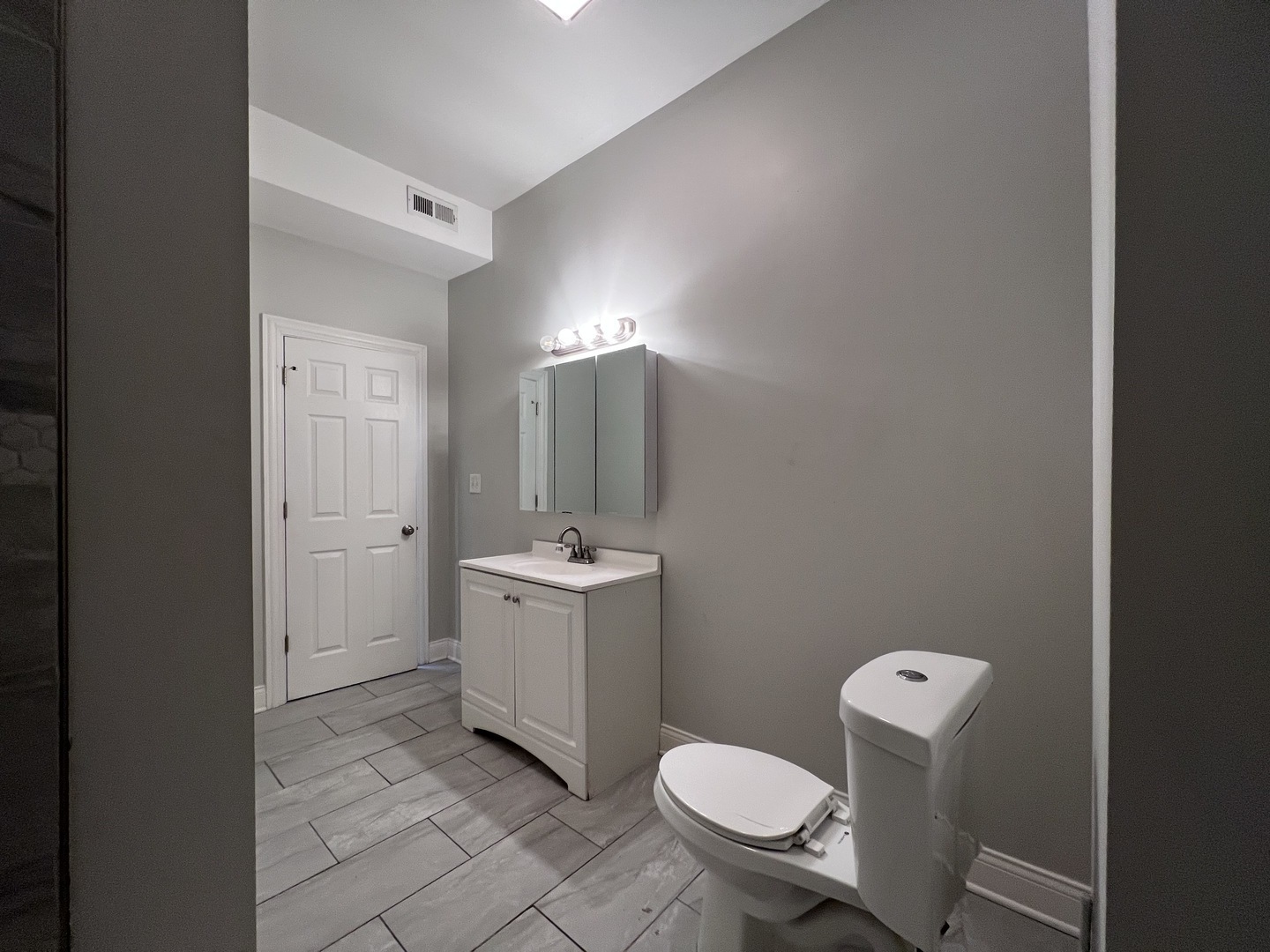 7057 South Normal Boulevard, Unit 2 Chicago, IL 60621 - Photo 34 of 46 a bathroom with a sink a toilet a mirror and vanity