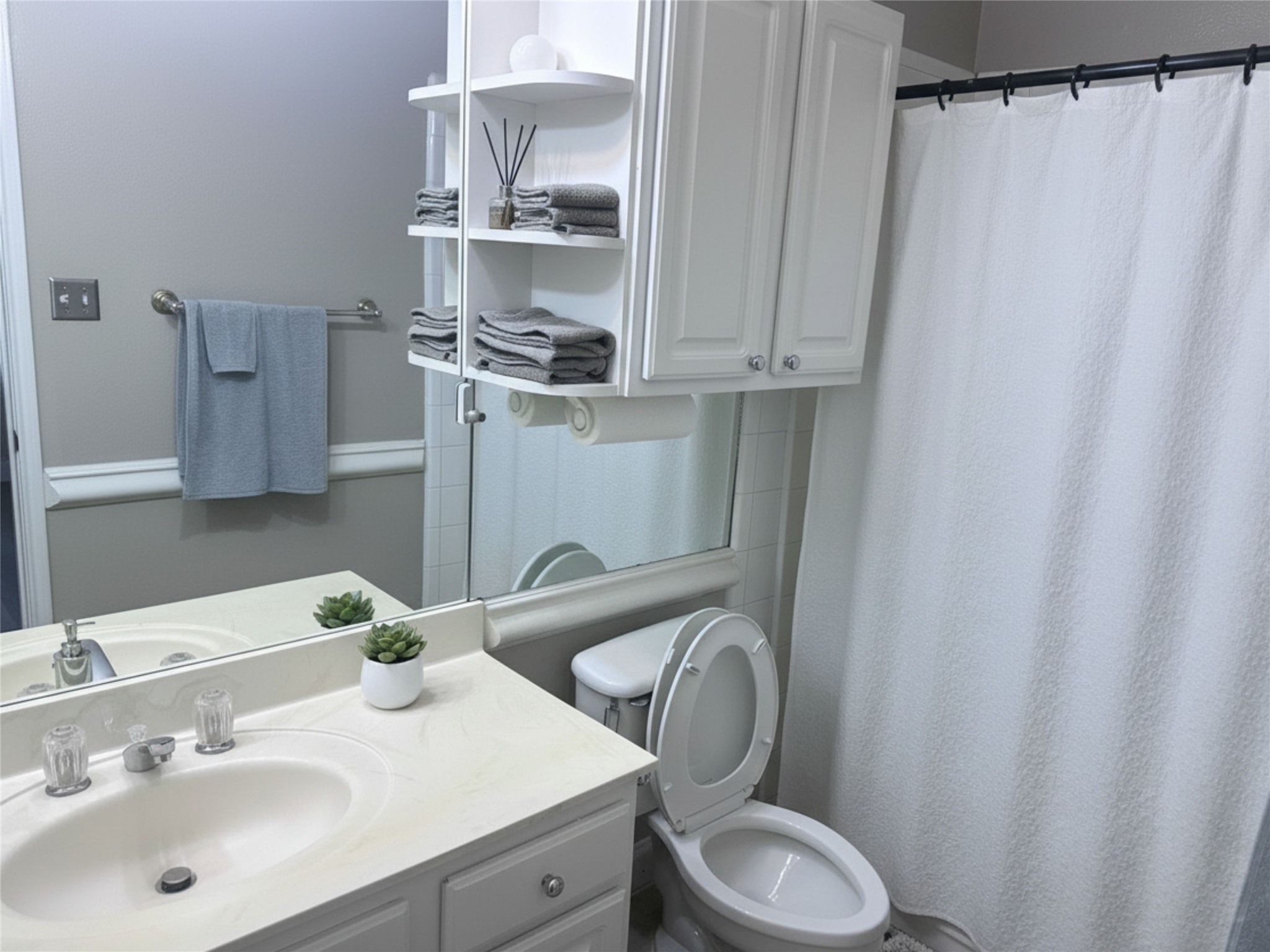 7347 Regency Square Court, Unit 7347 Houston, TX 77036 - Photo 2 of 12 a bathroom with a sink a toilet and shower curtain