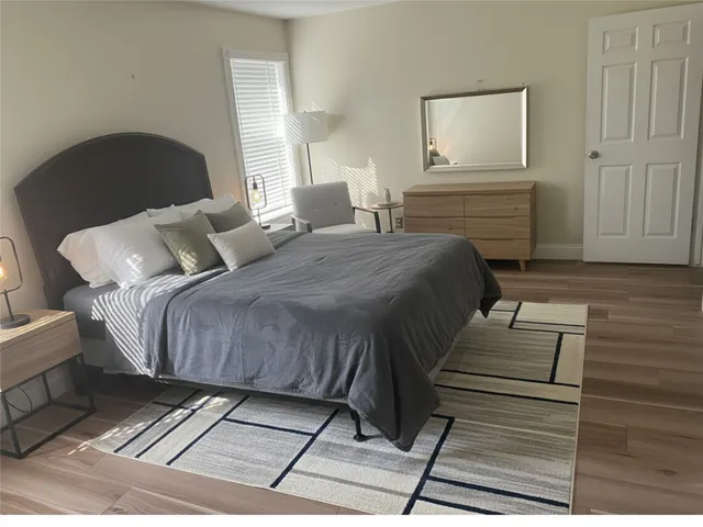 a bedroom with a bed and wooden floor