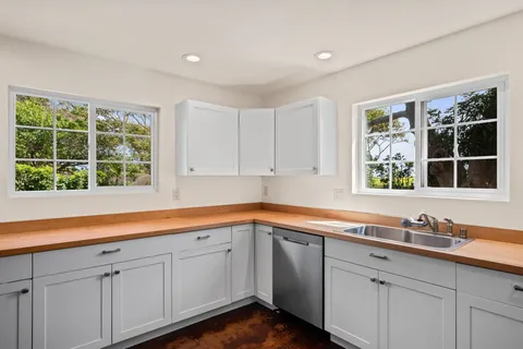a utility room with fridge dryer and bicycles