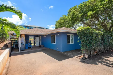 a view of a patio with table and chairs under an umbrella with a small yard