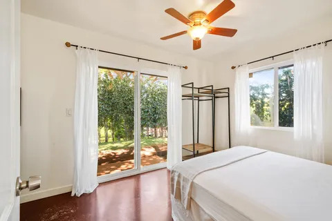 a bedroom with a bed dresser and window