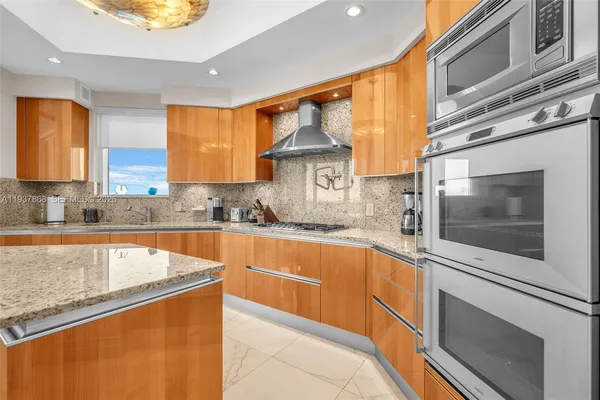 a kitchen with stainless steel appliances granite countertop a sink a stove and cabinets
