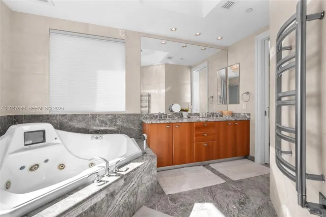 a bathroom with a tub sink and mirror