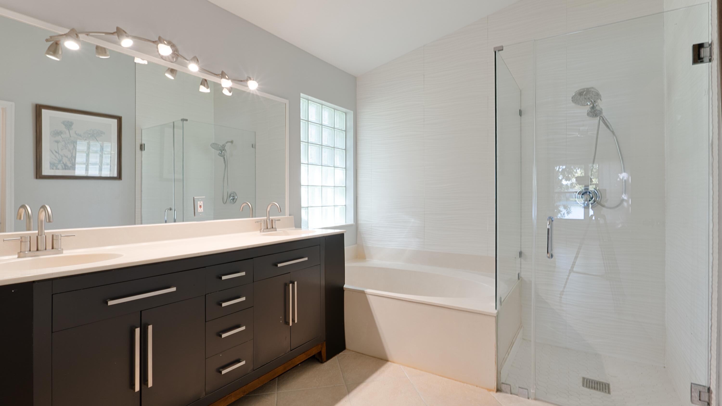 10789 Barque Court Boca Raton, FL 33498 - Photo 17 of 31 a bath room with a sink tub vanity and a mirror