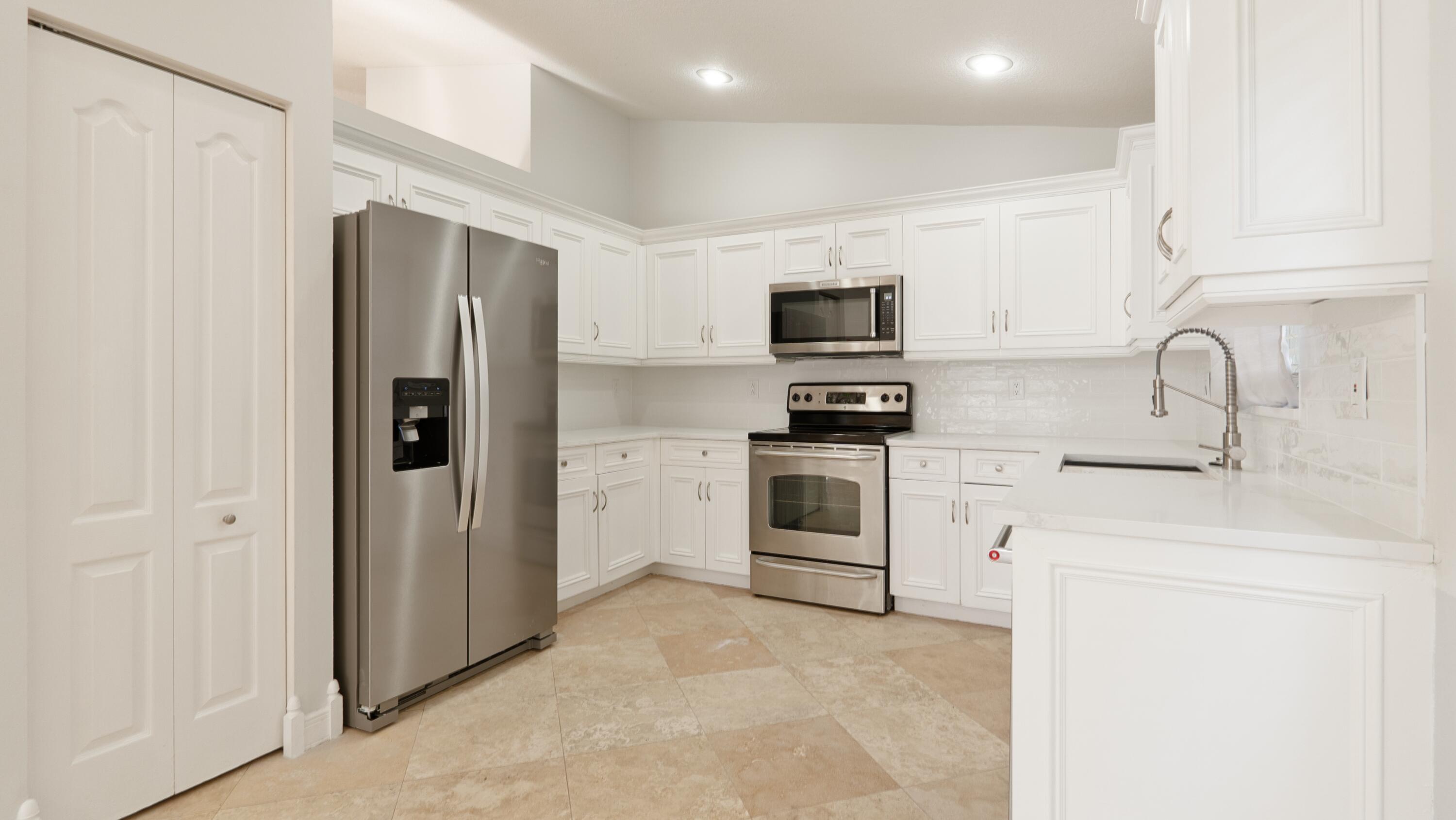 10789 Barque Court Boca Raton, FL 33498 - Photo 10 of 31 a kitchen with stainless steel appliances a refrigerator sink and white stove