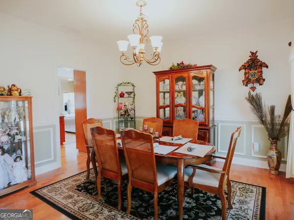 a dining room with furniture potted plants and wooden floor