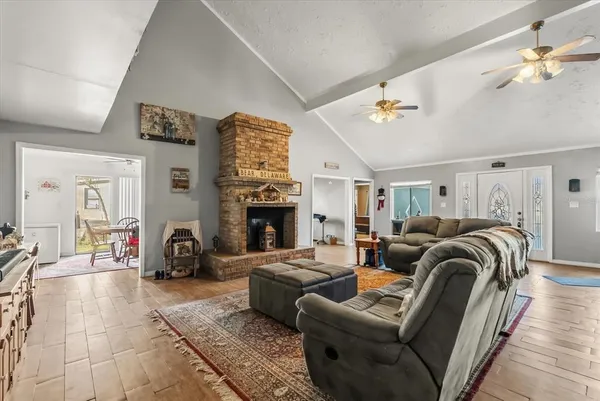 a living room with furniture a fireplace and a chandelier