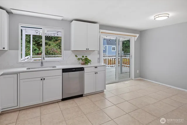 a kitchen with white cabinets and a window
