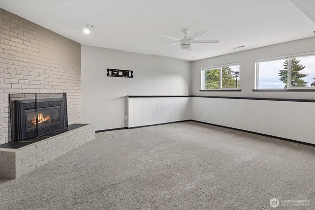 an empty room with windows and fireplace