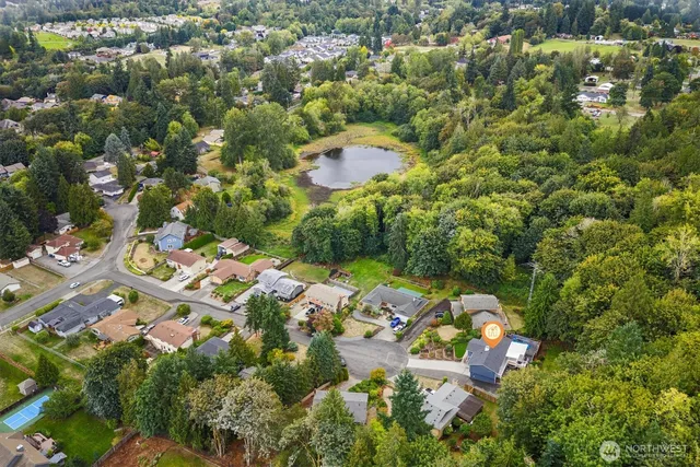 an aerial view of residential houses with outdoor space and trees