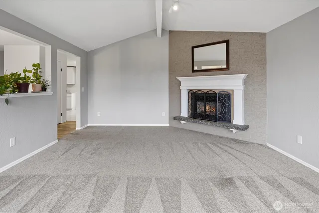 a view of an empty room with window and a fireplace