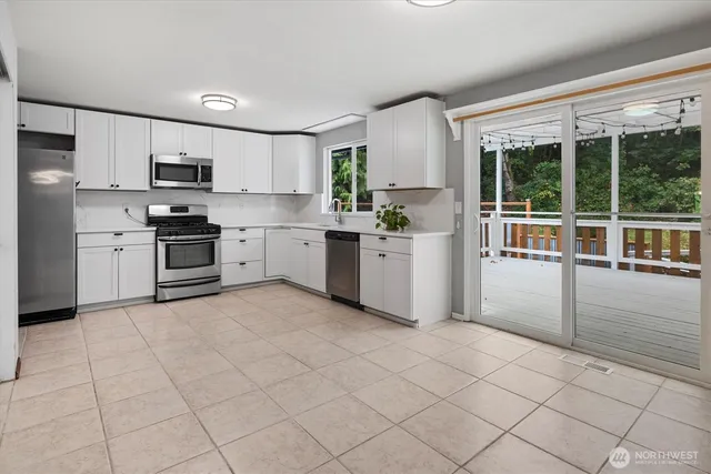 a kitchen with stainless steel appliances granite countertop a refrigerator and a stove top oven
