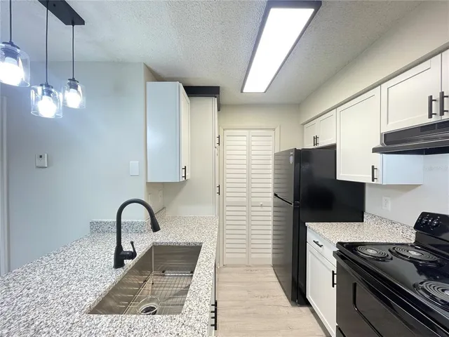 a view of a kitchen with wooden floor and electronic appliances