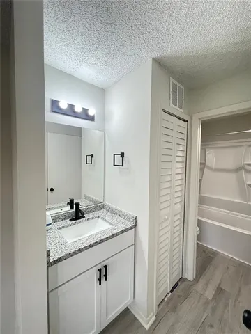a bathroom with a granite countertop sink and a mirror