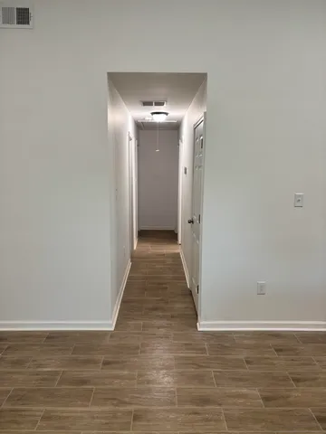 a view of a hallway with wooden floor
