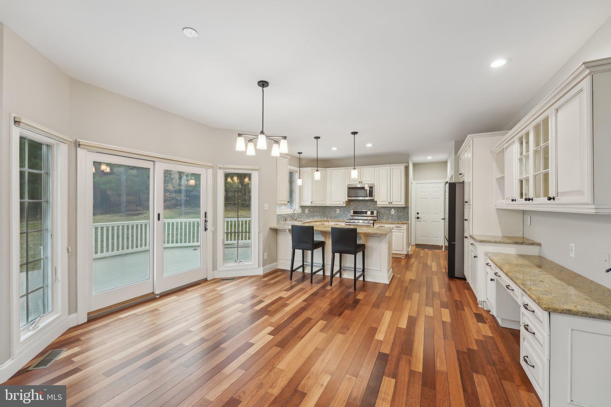 207 Summit Road Mount Laurel, NJ 08054 - Photo 12 of 57 a open kitchen with granite countertop a stove a sink dishwasher a dining table and chairs with wooden floor