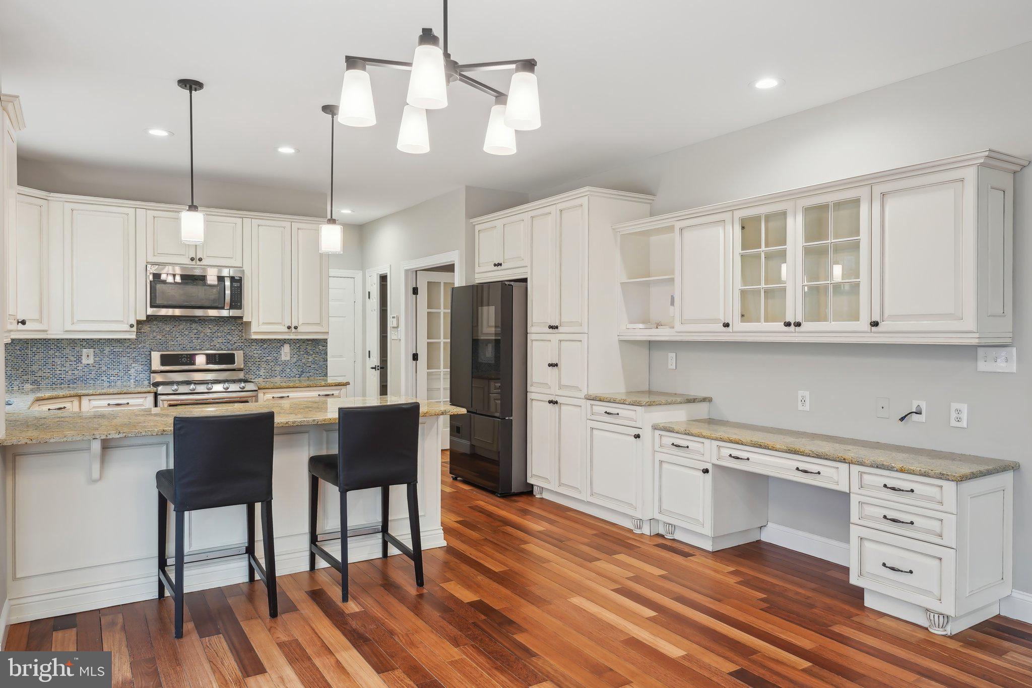 207 Summit Road Mount Laurel, NJ 08054 - Photo 13 of 57 a kitchen with stainless steel appliances kitchen island granite countertop a stove a sink dishwasher a refrigerator and white cabinets with wooden floor